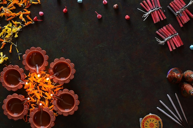 Diwali diya con petardi e decorazione floreale rangoli, lampada Diwali illuminata a mano, vista dall'alto