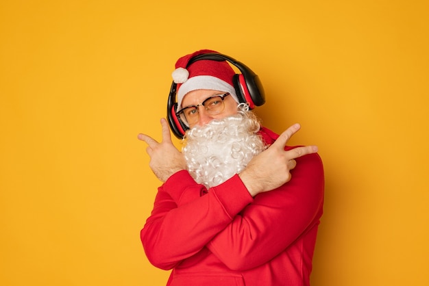 DJ Babbo Natale in cuffia. Canzoni e musica di Natale. sfondo giallo.