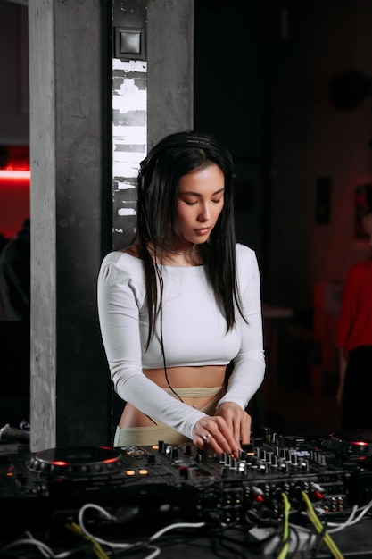 DJ femminile suona musica in un nightclub o in un altro evento utilizzando attrezzature DJ