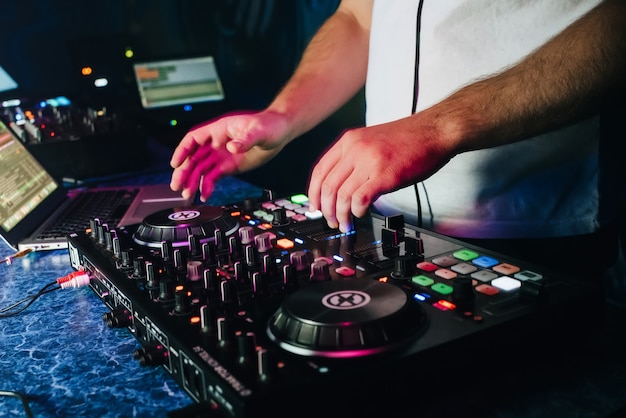 DJ in uno stand suonando un mixer in un night club