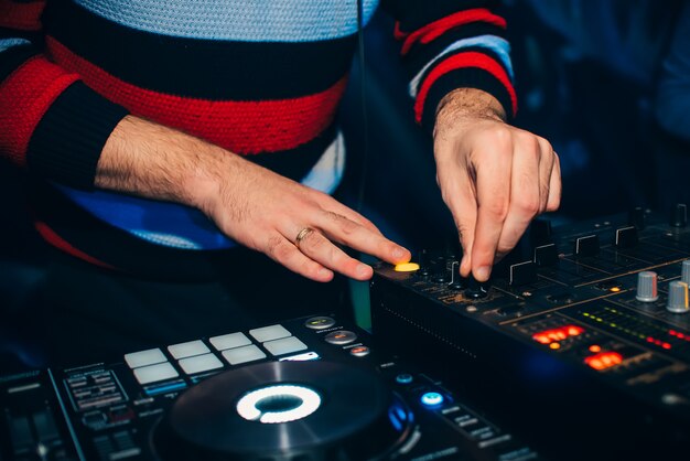 DJ in uno stand suonando un mixer in un night club