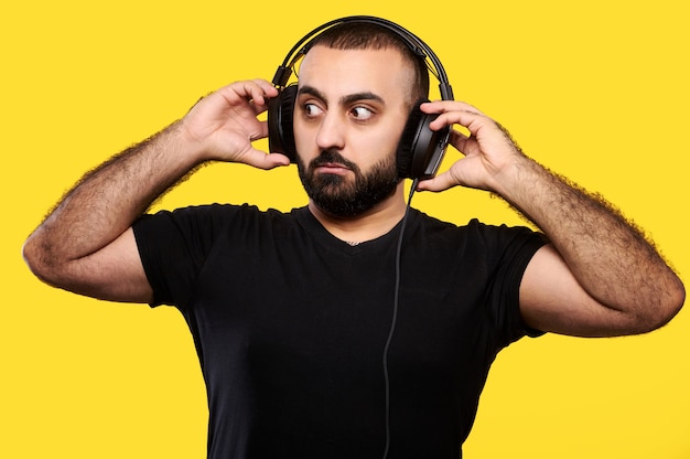 DJ musicista arabo sorpreso con la barba ascolta musica in cuffia. Giornata internazionale dei DJ