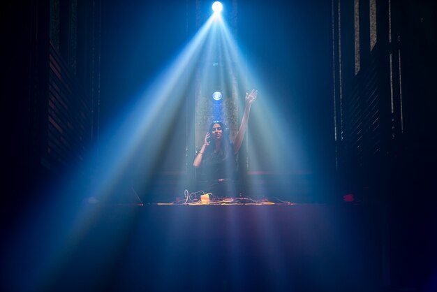 DJ sul palco in discoteca night club mescolando musica techno