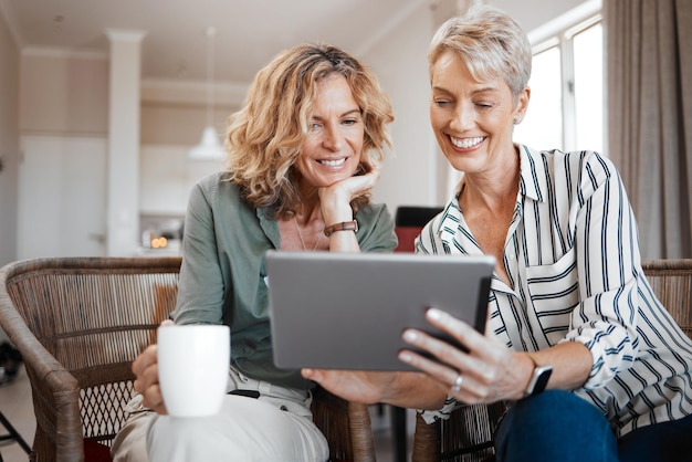 Dobbiamo guardare questi video Scatto di due amiche che bevono caffè mentre usano una tavoletta digitale