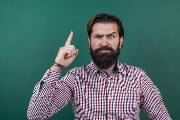 Docente universitario brutale con la barba lunga all'ispirazione della lavagna