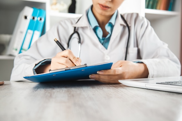 Documento della mano della donna del medico con la penna