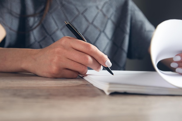 Documento di firma della donna e penna della tenuta della mano