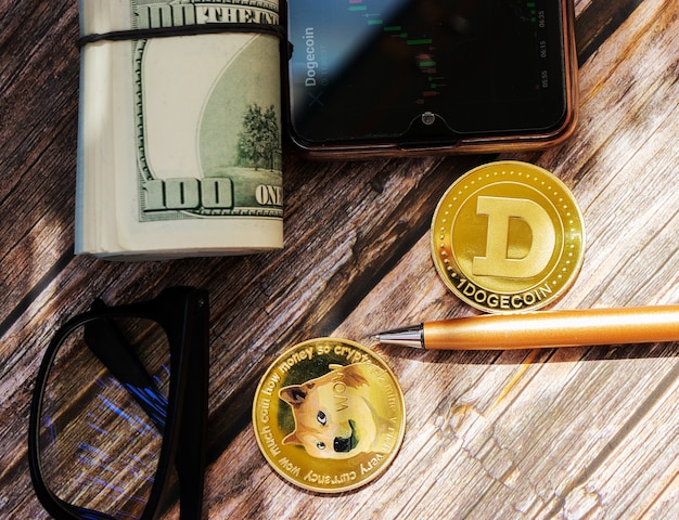 Dogecoin, criptovaluta su uno sfondo di legno con soldi in primo piano vista dall'alto