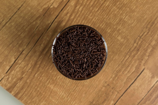 Dolce al cioccolato brasiliano chiamato Brigadeiro in vaso su sfondo di legno della scrivania Versione vegana