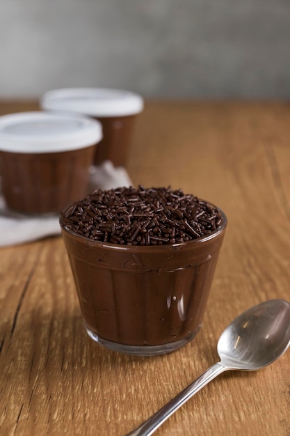 Dolce al cioccolato brasiliano chiamato Brigadeiro in vaso su sfondo di legno della scrivania Versione vegana