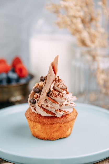 Dolce al cioccolato con morbida crema di latte. Tartelletta con gocce di cioccolato su uno sfondo di legno.