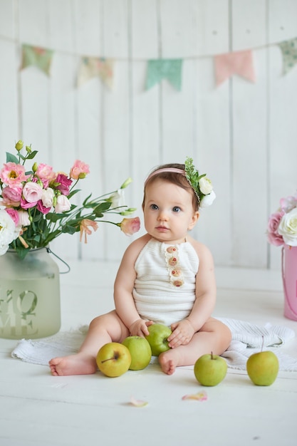 Dolce bambino divertente nel cappello con fiori. EasterCute bambina 6 mesi con cappello a fiori.