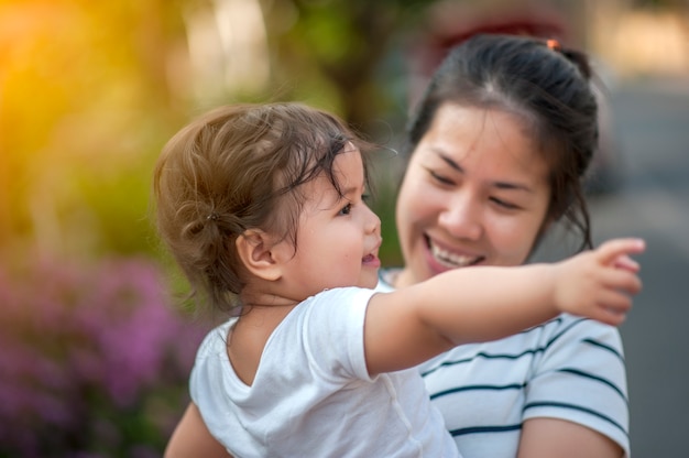 Dolce Bella bambina con abbraccio di madre e giocando.