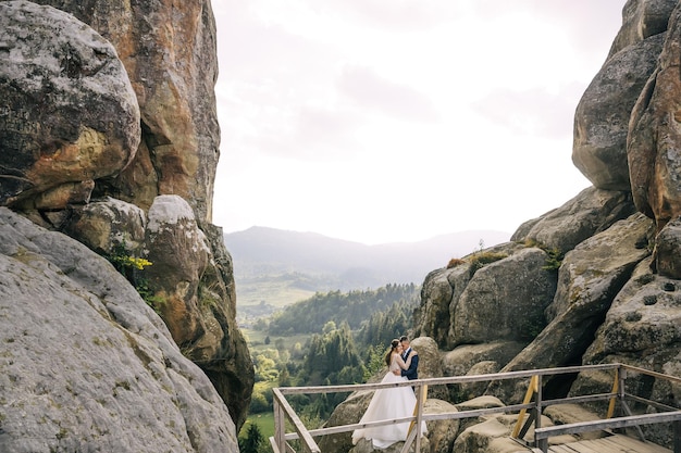 Dolce bellissimo abbraccio degli sposi n in montagna tra le rocce Viaggio di nozze nella natura