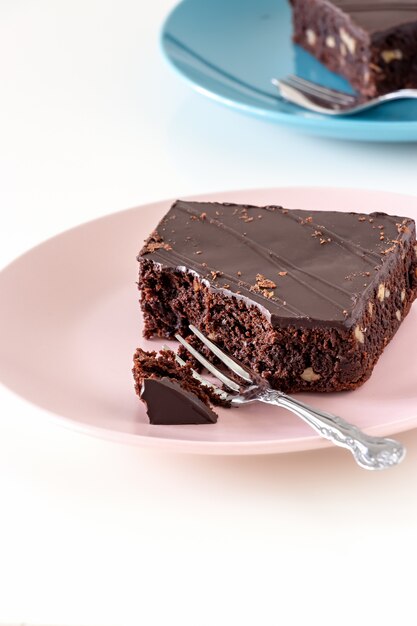 Dolce casalingo del brownie del vegano del cioccolato fondente con il fondo leggero del piatto di dadi. Messa a fuoco selettiva