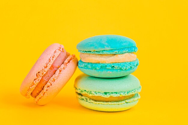 Dolce di mandorle colorate unicorno rosa blu macaron o amaretto dolce torta isolato su giallo alla moda moda moderna