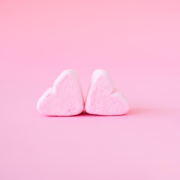 Dolce forma di cuore di marshmallow su sfondo rosa Decorazione per amore e concetto di giorno di San Valentino