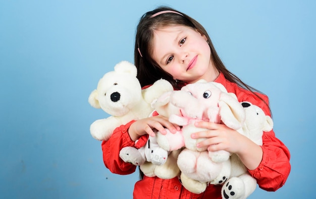 Dolce infanzia Collezionare giocattoli hobby Custodire i ricordi dell'infanzia Concetto di infanzia Piccola ragazza sorridente faccia con i giocattoli preferiti Infanzia felice Bambina gioca con peluche orsacchiotto