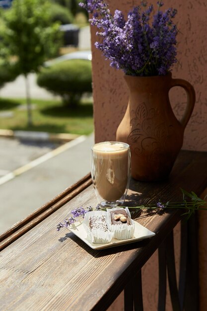 Dolce naturale al cacao senza zucchero con bicchiere di latte e fiori di lavanda nella terrazza del caffè