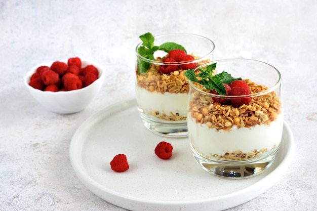 dolce sano con yogurt e muesli con lampone decorato con foglie di menta e frutti di bosco