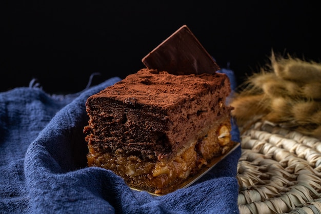 Dolce Sofia con strati di mousse al cioccolato e arachidi caramellate ricoperte di cacao in polvere.