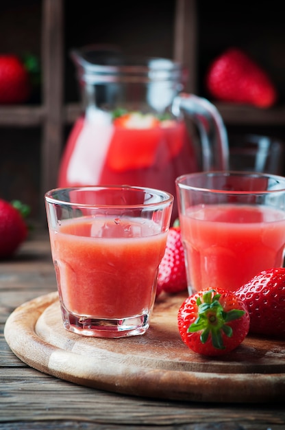 Dolce succo di fragole fresche sul tavolo di legno