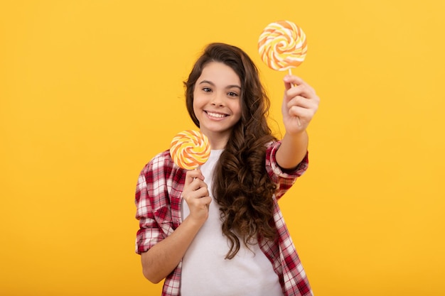 Dolce vita infanzia teen cura dentale dolce dente yummy ragazza felice tenere lecca-lecca lecca-lecca bambino hipster bambino con lunghi capelli ricci tenere lecca-lecca caramelle di zucchero sul bastone caramelle negozio di caramelle