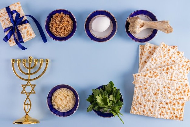 Dolcetti tradizionali per la festa ebraica della Pasqua un candeliere minore matzo fatto in casa vista superiore spazio di cornice di sfondo blu per il testo