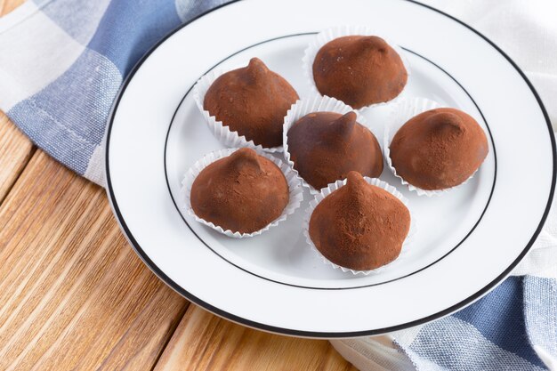 Dolci di tartufi di cioccolato nel piatto sulla tavola di legno