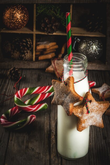 Dolci e dolcetti di Natale, Bottiglie con latte per Babbo Natale con biscotti di panpepato con decorazioni di corda e decorazioni natalizie, legno vecchio,