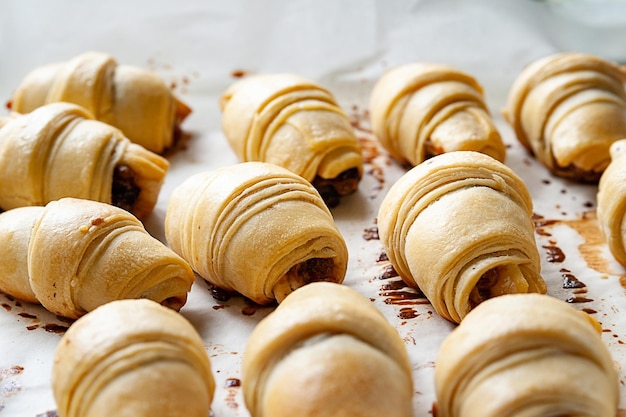 Dolci fatti in casa I panini dolci con ripieno sono impilati su carta da forno su una teglia