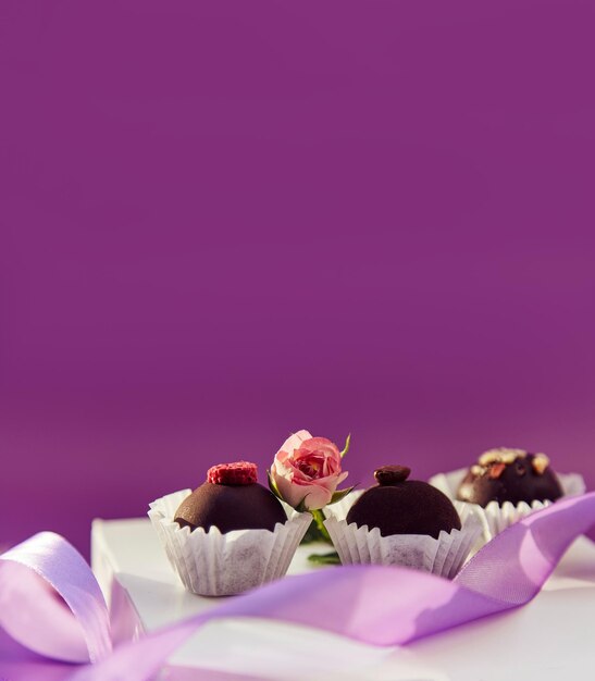 Dolci festosi al cioccolato Delicate piume rosa e nastro viola Motivo di colore viola con spazio per la copia Banner extra largo