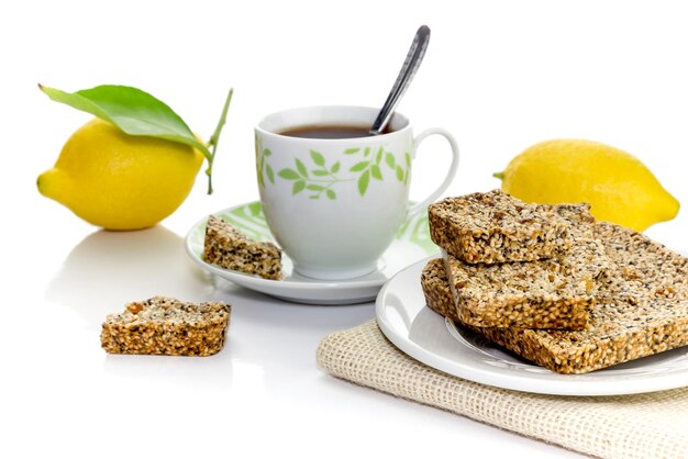 Dolci greci tradizionali nazionali pasteli con miele di sesamo, papavero e scorza di limone e tazza di tè