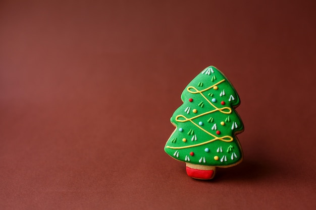 Dolci natalizi. Tradizioni natalizie. Pan di zenzero dell'albero di Natale sulla festa rosso scuro di .copyspace