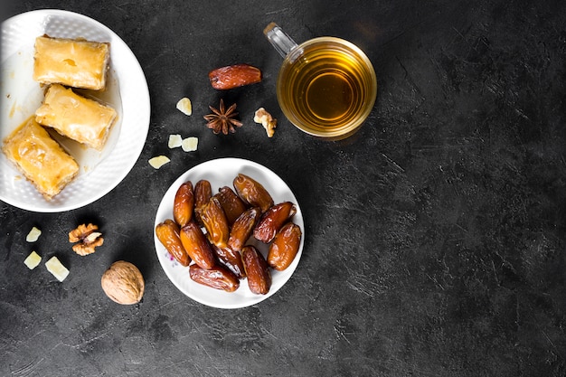 Dolci orientali con datteri frutta e tazza di tè