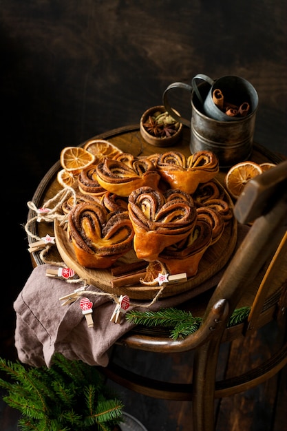 Dolci panini alla cannella fatti in casa a forma di cuore su una vecchia sedia retrò. Umore del nuovo anno.