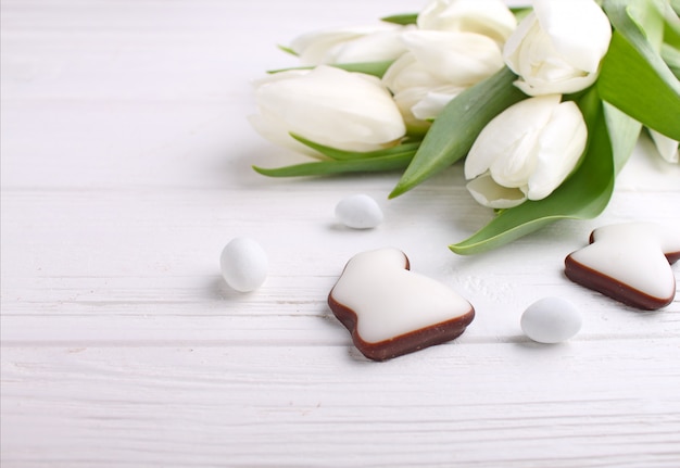 Dolci per festeggiare la Pasqua. Tulipani bianchi, uova di cioccolato e coniglietto di pasqua.
