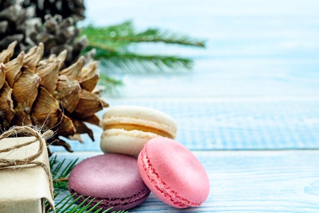 Dolci regali di macarons e pigne e su sfondo blu Sfondo di Natale Composizione di Capodanno