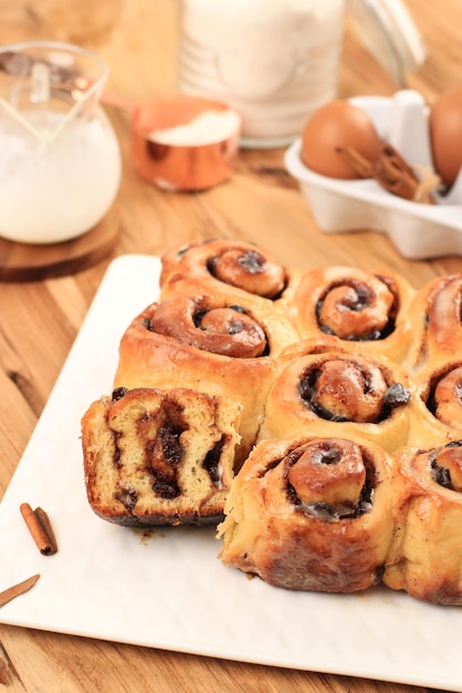 Dolci Rotolo Di Cannella Con Cannella In Polvere, Tagliato A Metà. Servire su un piatto bianco