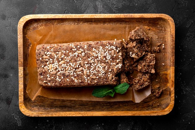 dolci vegani sani senza zucchero noci halva con semi e sesamo sul piatto di legno e grigio scuro