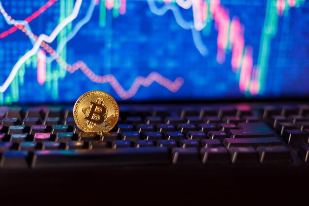 Dollari a clessidra e bitcoin sulla tastiera di un computer sullo sfondo dei grafici