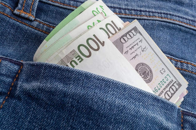 dollari ed euro che spuntano dalla tasca dei jeans