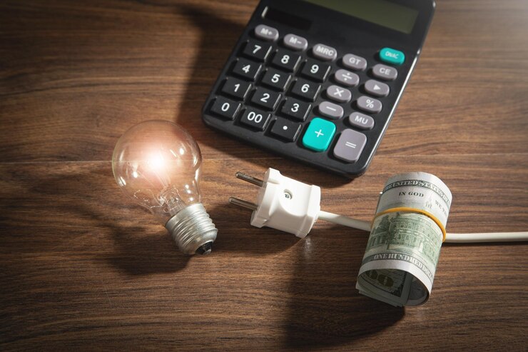 Dollaro banconote calcolatrice lampadina spina elettrica sul tavolo di legno Aumento dei prezzi dell'elettricità