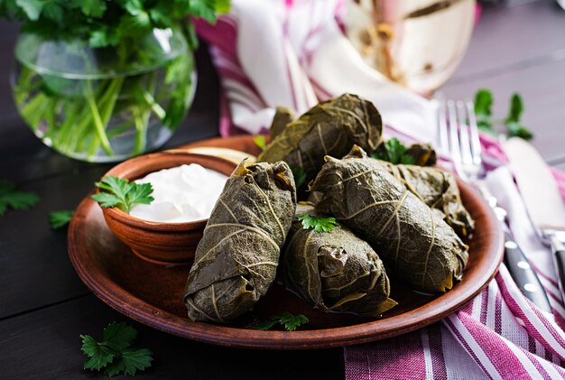 Dolma Foglie d'uva ripiene con riso e carne su tavola scura Cucina mediorientale