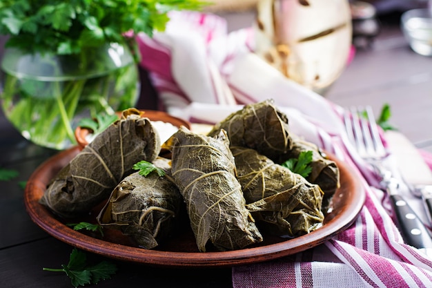 Dolma Foglie d'uva ripiene con riso e carne su tavola scura Cucina mediorientale