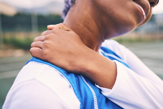 Dolore al collo infortunio sportivo e atleta di netball su un campo sportivo all'aperto con problemi articolari o muscolari Esercizio di allenamento e mani della donna nera che tengono il corpo con problemi di benessere dall'allenamento di gioco