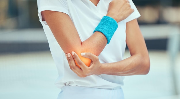 Dolore e infortunio al gomito del tennista con una donna sportiva che tiene la sua articolazione durante l'allenamento e l'esercizio fisico Salute e incidente con un'atleta in una partita o in una partita su un campo esterno