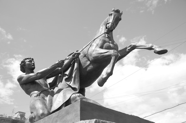 Domatore di cavalli scultura (1851) di Peter Klodt sul ponte Anichkov a San Pietroburgo, Russia. Bianco e nero