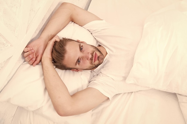 Domenica pigra con sesso mattutino uomo sdraiato camera da letto tempo per rilassarsi concetto di salute maschile uomo sveglio a letto spensierato atteggiamento seducente maschile singolo uomo sexy a letto sveglia presto la mattina ridurre lo stress