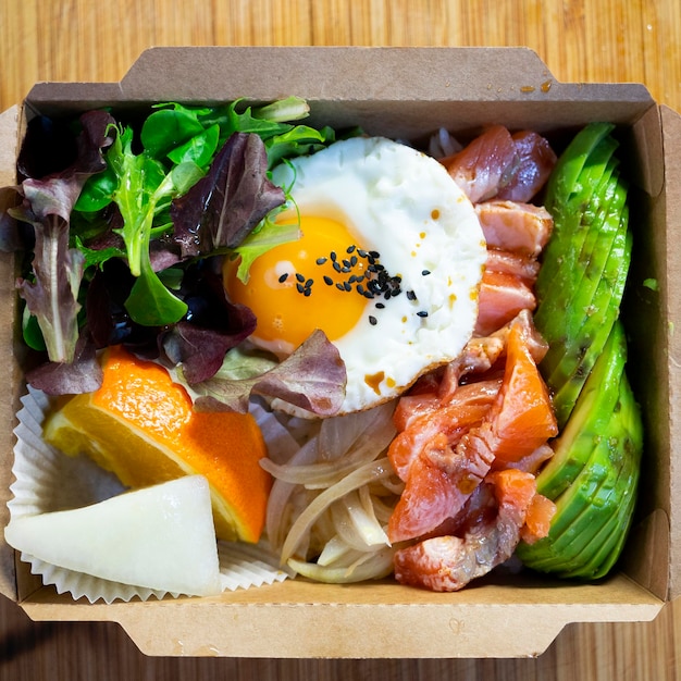 Donburi di salmone con uovo in cima. Pranzo al sacco giapponese.